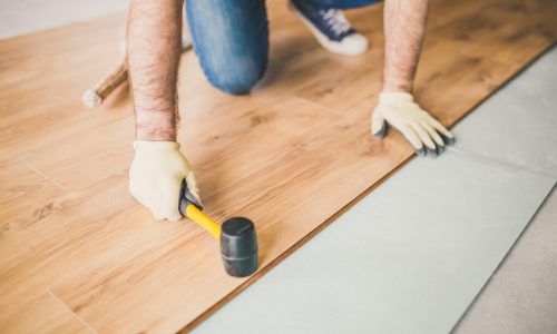 Adult man lays the laminate panel on the substrate with the technology