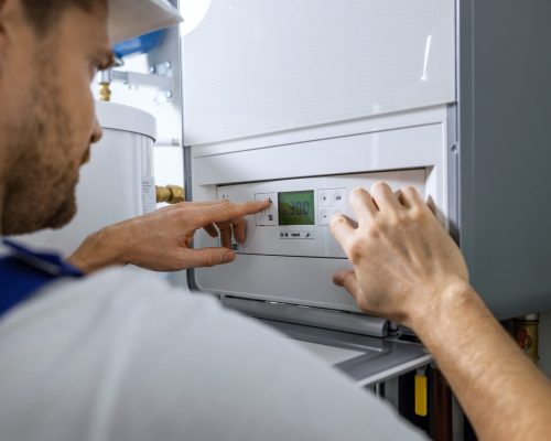 worker set up new central gas heating boiler for home